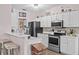 Bright kitchen with white cabinetry, stainless steel appliances, and a breakfast bar at 1212 Windy Bluff Dr, Minneola, FL 34715