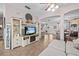 Open-concept living area with tile floors, a decorative TV stand and view into dining room at 1212 Windy Bluff Dr, Minneola, FL 34715