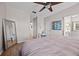 Spacious main bedroom featuring wood floors, a ceiling fan, and an adjacent bathroom and closet area at 1212 Windy Bluff Dr, Minneola, FL 34715