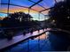 Relaxing backyard pool view with a stunning sunset backdrop providing a serene outdoor oasis at 1212 Windy Bluff Dr, Minneola, FL 34715