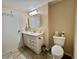 Neutral toned bathroom featuring a toilet, vanity, sink, and tile floors at 127 Hibiscus Way, Leesburg, FL 34748