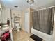 Bathroom with tile floors, a shower-tub combo, a toilet, and a dual-sink vanity at 127 Hibiscus Way, Leesburg, FL 34748