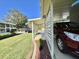 Exterior shot of carport area with red car parked and neatly landscaped lawn at 127 Hibiscus Way, Leesburg, FL 34748