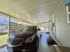 Carport with a red Buick Enclave parked, adjacent to the home's entrance at 127 Hibiscus Way, Leesburg, FL 34748