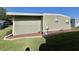 View of exterior with green siding, white trim, and manicured landscaping at 127 Hibiscus Way, Leesburg, FL 34748