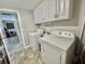 Laundry area with white cabinetry and modern appliances at 127 Hibiscus Way, Leesburg, FL 34748