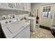 Convenient laundry room with washer, dryer, and upper cabinets at 127 Hibiscus Way, Leesburg, FL 34748