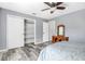 Bedroom features a ceiling fan, wood-look floors, closet, and gray walls at 12802 Amber Ave, Clermont, FL 34711