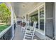 Relaxing front porch featuring classic rocking chairs and views of the surrounding landscaped yard at 12802 Amber Ave, Clermont, FL 34711