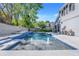 Backyard pool with blue tile accents, fountains, and patio seating with landscaping and a lawn beyond at 12802 Amber Ave, Clermont, FL 34711