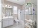 Bathroom featuring a shower with a curtain, toilet, and a sink with a vanity, complemented by a modern storage rack at 13146 Se 91St Court Rd, Summerfield, FL 34491
