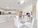 Open dining area with stainless steel barstools, kitchen, and view into the living room at 13146 Se 91St Court Rd, Summerfield, FL 34491