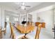 Spacious dining area with wood table set, modern ceiling fan, and an open view to other spaces at 13146 Se 91St Court Rd, Summerfield, FL 34491