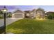 Charming home featuring a well-manicured lawn, a two-car garage, and a welcoming facade at 13146 Se 91St Court Rd, Summerfield, FL 34491