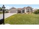 Single Gathering home with a well manicured front lawn, desert landscaping, and neutral colored stucco on a beautiful day at 13146 Se 91St Court Rd, Summerfield, FL 34491