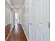 Hallway features wood floors, mirrored closet, and neutral color scheme, offering a clean aesthetic at 13146 Se 91St Court Rd, Summerfield, FL 34491