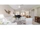 Bright living room features a black piano, white furniture, and neutral tones throughout at 13146 Se 91St Court Rd, Summerfield, FL 34491