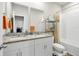 A bathroom featuring a double sink vanity with granite countertop, with bath and shower and white tile surround at 140 S Zuni Rd, St Cloud, FL 34771