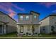 A modern two-story gray home has a small front yard with walkway to the front door at 140 S Zuni Rd, St Cloud, FL 34771