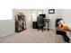 This home office includes a computer desk, rolling chair, and a bookshelf filled with books and decorative objects at 140 S Zuni Rd, St Cloud, FL 34771