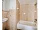 Cozy bathroom featuring peach tiles on the walls and a white sink and bathtub at 15747 Old Highway 50, Clermont, FL 34711