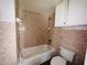 Cozy bathroom featuring peach tiles on the walls and a white sink, toilet, and bathtub at 15747 Old Highway 50, Clermont, FL 34711