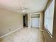 Bedroom features tile floors, ceiling fan, closet, and natural light from the window at 15747 Old Highway 50, Clermont, FL 34711