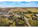Aerial view of a neighborhood with large green pastures, homes with mature trees, and long, paved driveways at 1603 Brookstone Ln, Fruitland Park, FL 34731
