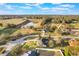 Aerial view of a home near a scenic pond and green pasture, featuring a long driveway and mature trees at 1603 Brookstone Ln, Fruitland Park, FL 34731