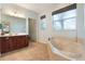 Luxurious bathroom featuring double vanity, marble tub, and an abundance of natural light at 1603 Brookstone Ln, Fruitland Park, FL 34731