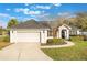 Charming single-story home with a well-manicured lawn and a two-car garage, enhanced by beautiful landscaping and a cozy entryway at 1603 Brookstone Ln, Fruitland Park, FL 34731