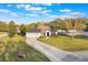 Traditional-style home showcasing a well-maintained lawn, a two-car garage, and an elongated driveway, nestled among mature trees at 1603 Brookstone Ln, Fruitland Park, FL 34731