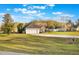 Spacious home featuring a two-car garage and a long driveway, set on a large lot with mature trees and lush green grass at 1603 Brookstone Ln, Fruitland Park, FL 34731