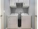 Well-lit laundry room featuring washer, dryer, overhead storage, and neutral paint at 1603 Brookstone Ln, Fruitland Park, FL 34731