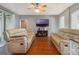 Spacious living room with modern entertainment center and hardwood floors at 1603 Brookstone Ln, Fruitland Park, FL 34731