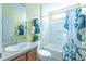 Bright bathroom featuring a tub with blue-patterned curtain and modern fixtures at 1617 Lakewood Dr, The Villages, FL 32162