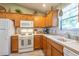 Well-equipped kitchen with a gas range, white appliances, and updated countertops at 1617 Lakewood Dr, The Villages, FL 32162