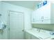 Functional laundry room featuring modern washer and dryer under white storage cabinets at 1617 Lakewood Dr, The Villages, FL 32162
