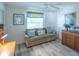 Cozy living room with a sofa, wood-look floors, and a window with natural light at 1617 Lakewood Dr, The Villages, FL 32162