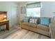 Cozy living room with a sofa, wood-look floors, and a window with natural light at 1617 Lakewood Dr, The Villages, FL 32162
