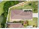 Overhead view of a landscaped home with a brown roof, a stone patio, and a pristine white fence at 1622 Valley Falls Way, The Villages, FL 32162