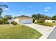 Charming single-story home with a well-manicured lawn, a long driveway, and a two-car garage at 1622 Valley Falls Way, The Villages, FL 32162
