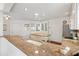 Bright kitchen with white cabinets and an island next to a stainless steel refrigerator at 1622 Valley Falls Way, The Villages, FL 32162