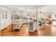 Bright kitchen with white cabinetry, an island, stainless steel appliances, and hardwood floors at 1622 Valley Falls Way, The Villages, FL 32162