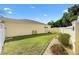 Landscaped side yard featuring a well-kept lawn, a gravel path, and a white fence for privacy at 1622 Valley Falls Way, The Villages, FL 32162