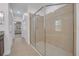 A modern glass shower suite in the main bathroom, with neutral tile and glass door. Doors lead back to the Primary suite at 16611 Spring Park Dr, Clermont, FL 34711