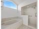 Bright bathroom with soaking tub, walk-in shower, and a large window at 1676 E Spring Ridge Cir, Winter Garden, FL 34787