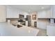 Well-lit kitchen boasts stainless steel appliances, white cabinetry, quartz counters, and a mosaic backsplash at 16865 Se 94Th Sunnybrook Cir, The Villages, FL 32162