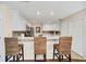 Bright kitchen featuring white cabinets, stainless steel appliances, mosaic backsplash, and a breakfast bar with three stools at 16865 Se 94Th Sunnybrook Cir, The Villages, FL 32162