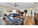 Living room with hardwood floors, ceiling fan, and leather sofas at 16865 Se 94Th Sunnybrook Cir, The Villages, FL 32162